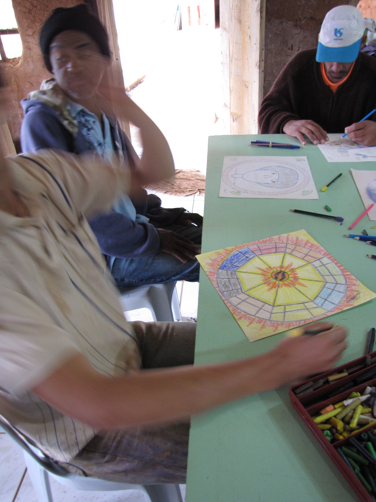Participantes realizando desenhos com lápis coloridos