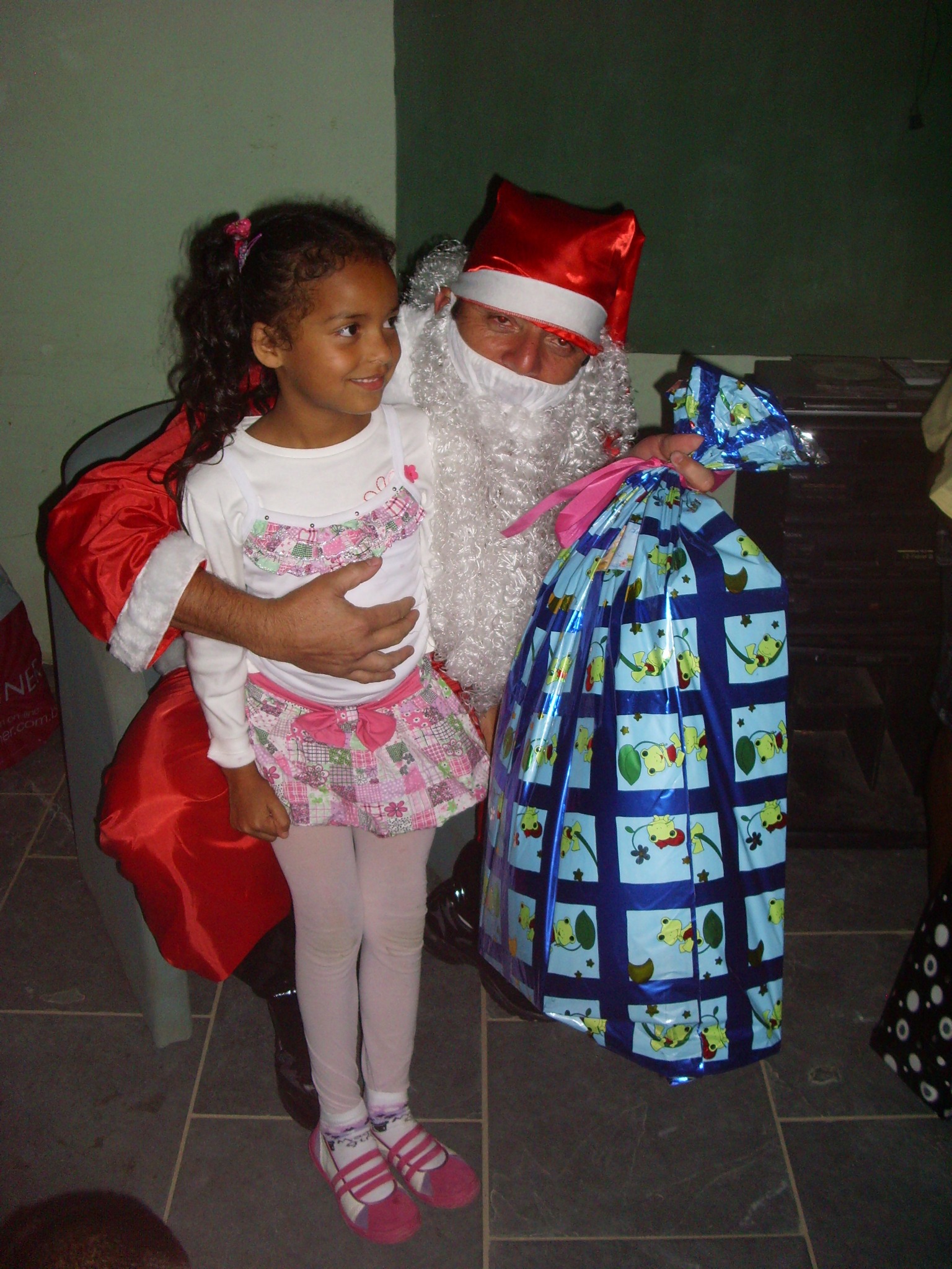 Papai Noel entregando presente a uma criança